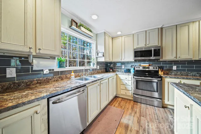 a kitchen with stainless steel appliances granite countertop a stove sink and cabinets