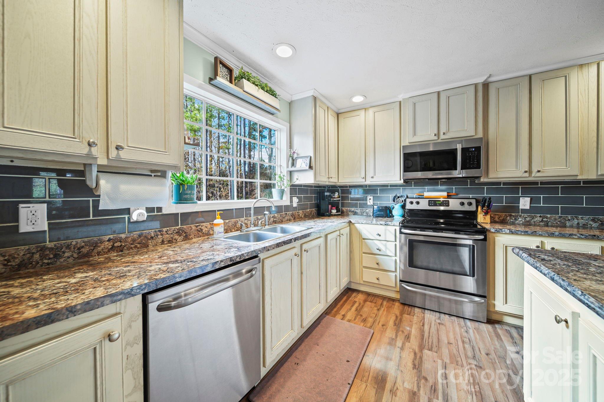30291 C Red Hill Road Albemarle, NC 28001 - Photo 10 of 45 a kitchen with stainless steel appliances granite countertop a stove sink and cabinets