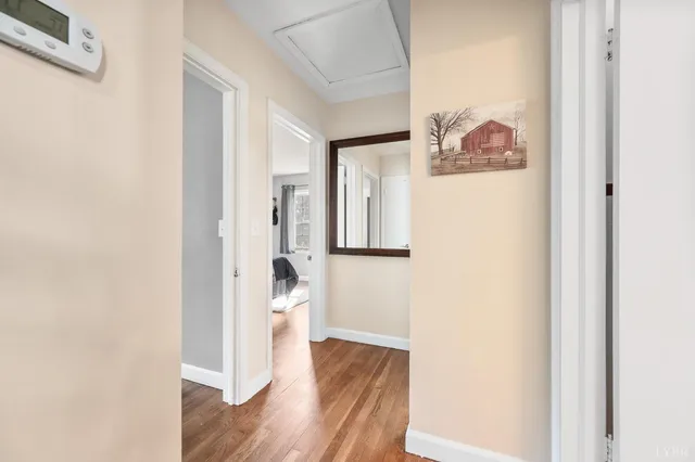 a view of a hallway with wooden floor and closet