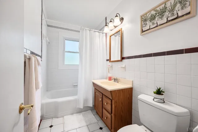 a bathroom with a toilet sink and mirror with bathtub