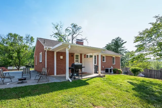 a view of a house with a yard and sitting area