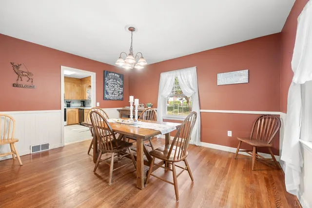 a view of a dining room with furniture wooden floor and chandelier