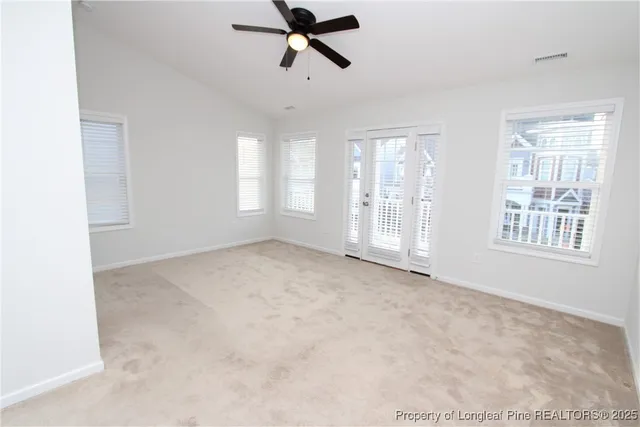 an empty room with a ceiling fan and window