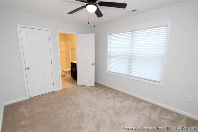 an empty room with closet and a chandelier fan