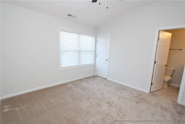 an empty room with a ceiling fan and a window