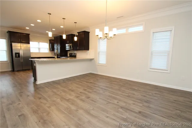 an open kitchen with kitchen island white cabinetry and refrigerator