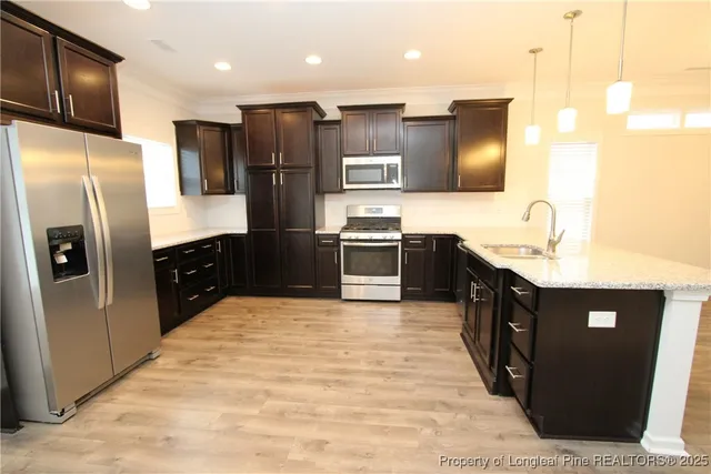 a kitchen with stainless steel appliances granite countertop a refrigerator and a sink