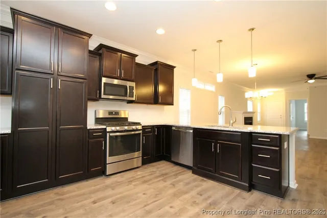 a kitchen with stainless steel appliances granite countertop a refrigerator and a sink