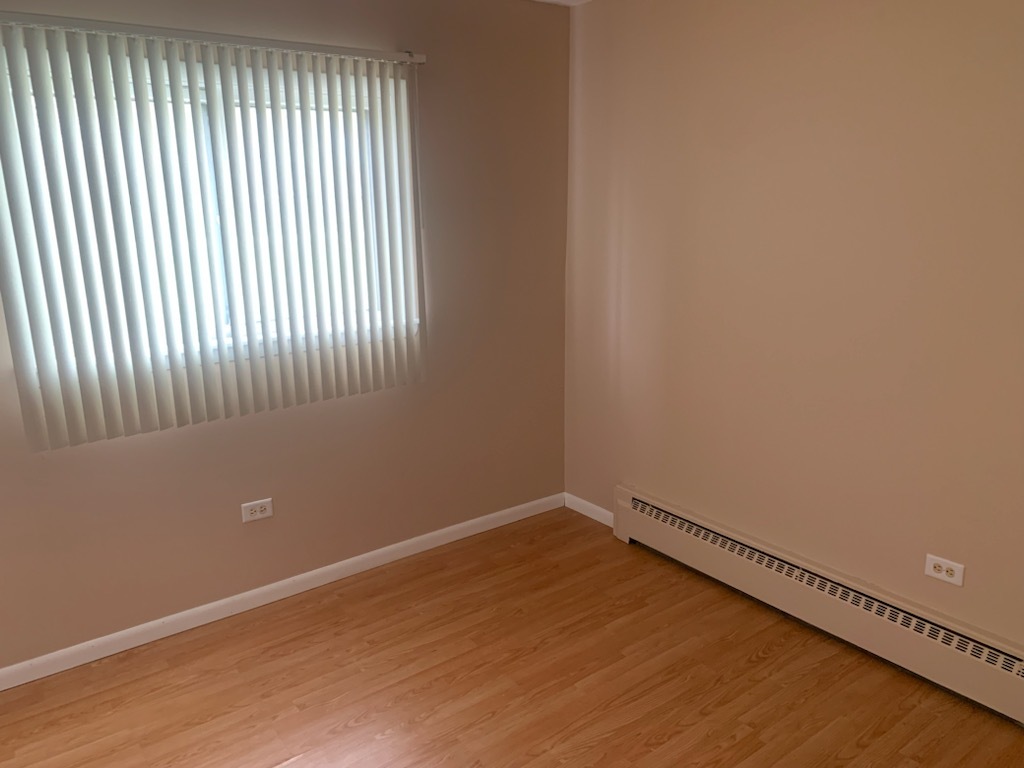 239 Northway Park Road, Unit 12 Machesney Park, IL 61115 - Photo 12 of 15 a view of an empty room with wooden floor and a window