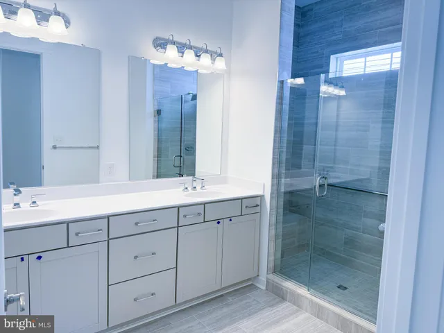 a bathroom with a shower sink and mirror