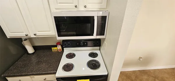a close view of kitchen stove a microwave and a stove