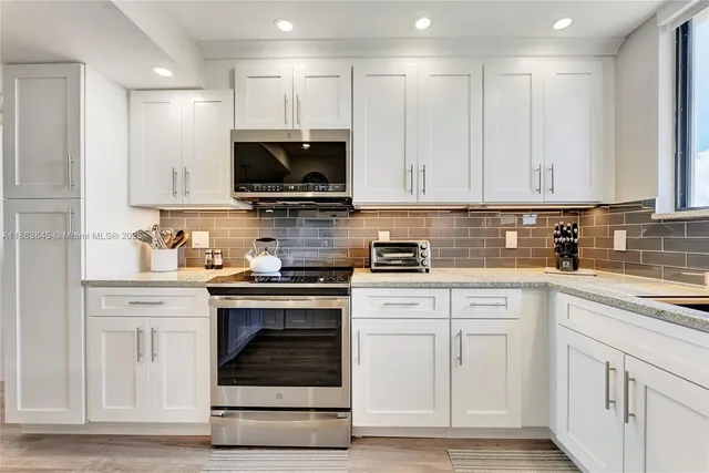 a kitchen with white cabinets and stainless steel appliances