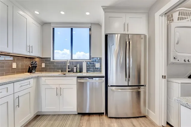 a kitchen with stainless steel appliances a refrigerator sink and cabinets