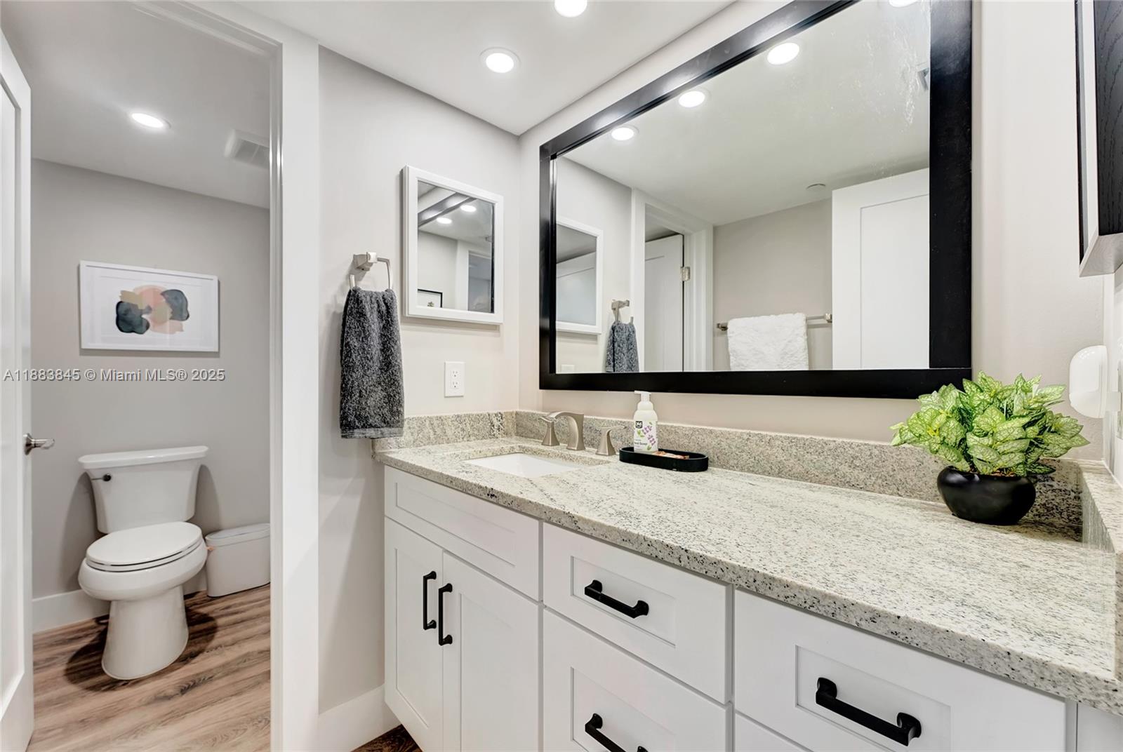 200 Ocean Trail Way, Unit 701 Jupiter, FL 33477 - Photo 18 of 27 a bathroom with a granite countertop sink a toilet and a mirror