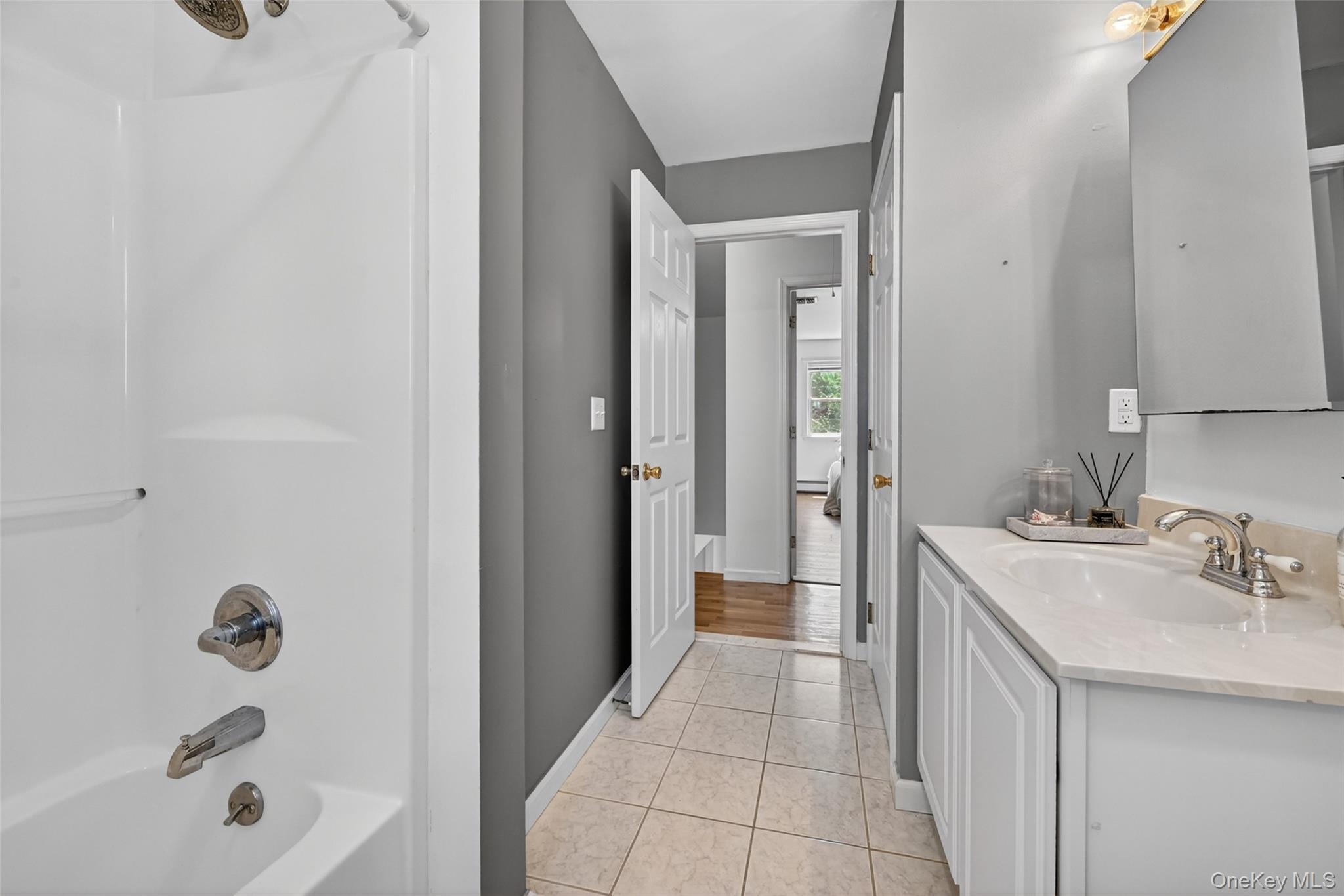 19 Bull Mine Road Chester, NY 10918 - Photo 27 of 42 Bathroom featuring a shower/tub combination with chrome fixtures, a single vanity with white cabinetry and a light-toned countertop, and neutral-toned tiled flooring