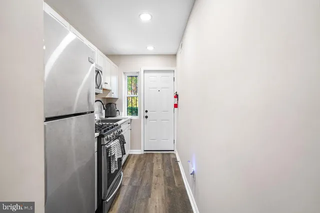 a view of a hallway with wooden floor and staircase