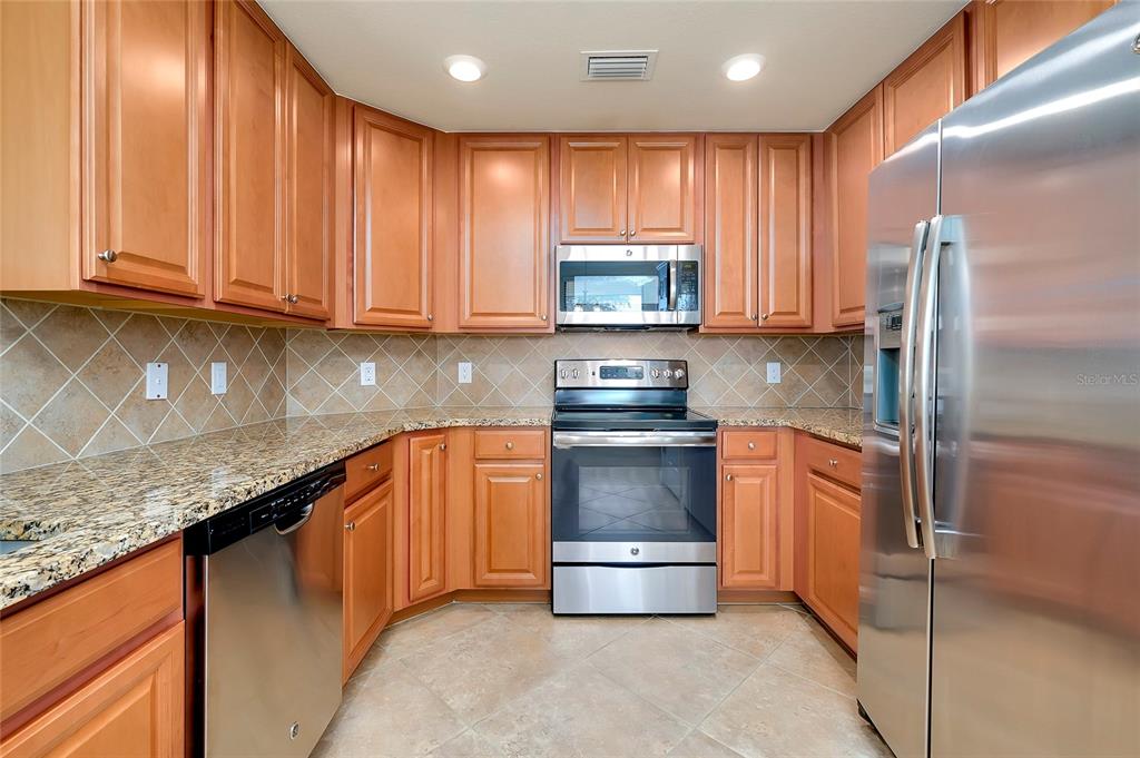 20100 Ragazza Circle, Unit 101 Venice, FL 34293 - Photo 28 of 100 a kitchen with stainless steel appliances granite countertop a refrigerator stove a sink and a microwave