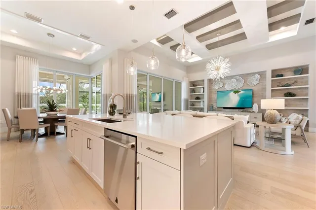 a large white kitchen with a large window and chairs