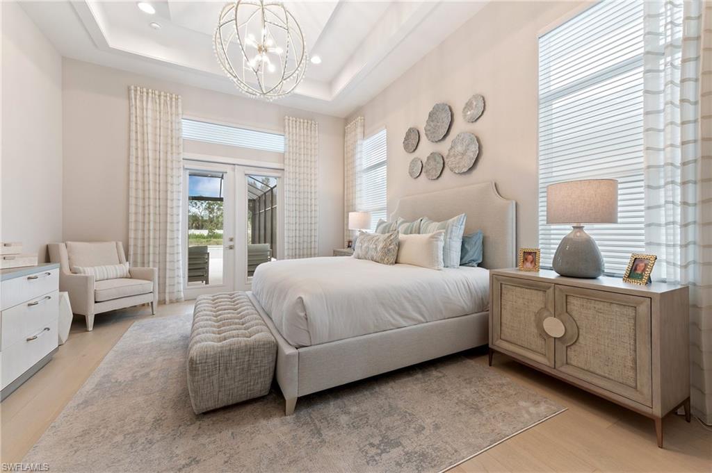 8916 Nevis Way Naples, FL 34112 - Photo 18 of 50 a bedroom with a bed and a chandelier