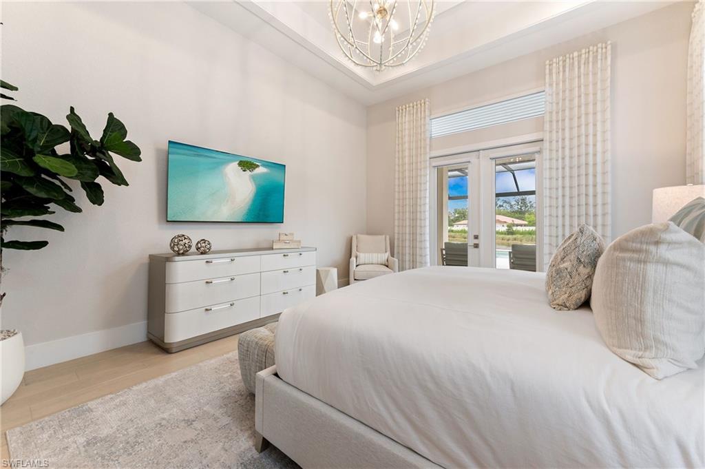 8916 Nevis Way Naples, FL 34112 - Photo 19 of 50 a bedroom with a bed and a flat screen tv