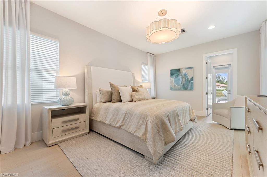 8916 Nevis Way Naples, FL 34112 - Photo 24 of 50 a bedroom with a bed and a chandelier