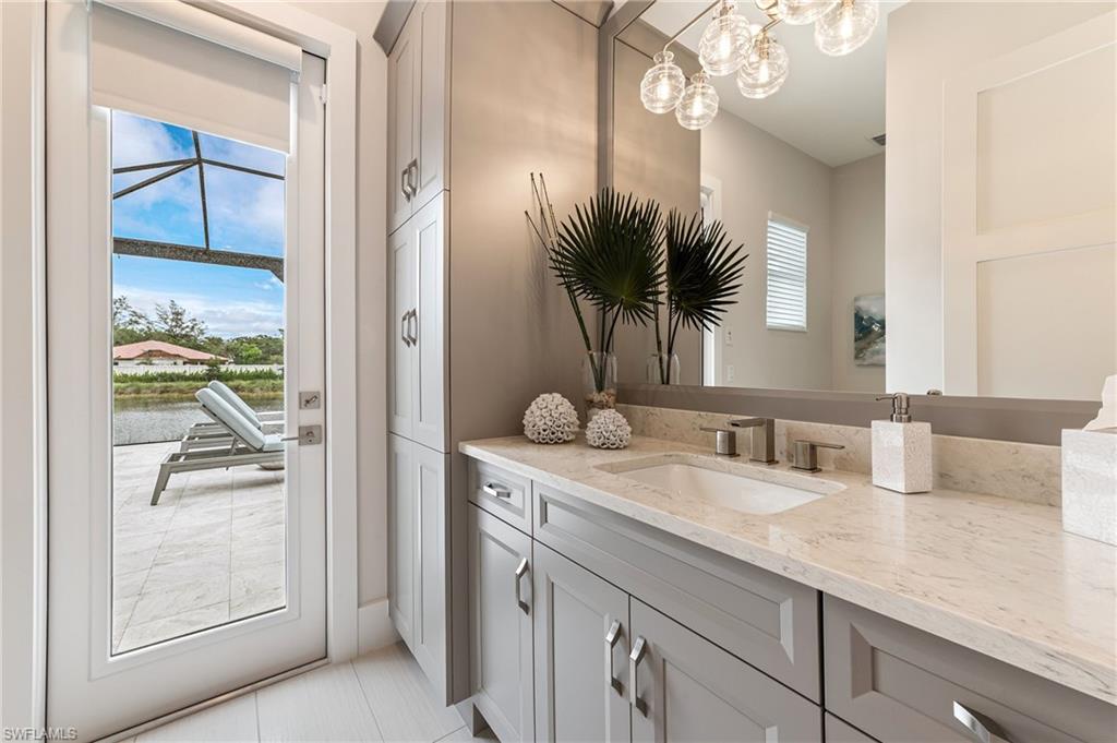 8916 Nevis Way Naples, FL 34112 - Photo 26 of 50 a bathroom with a granite countertop sink a mirror and a shower