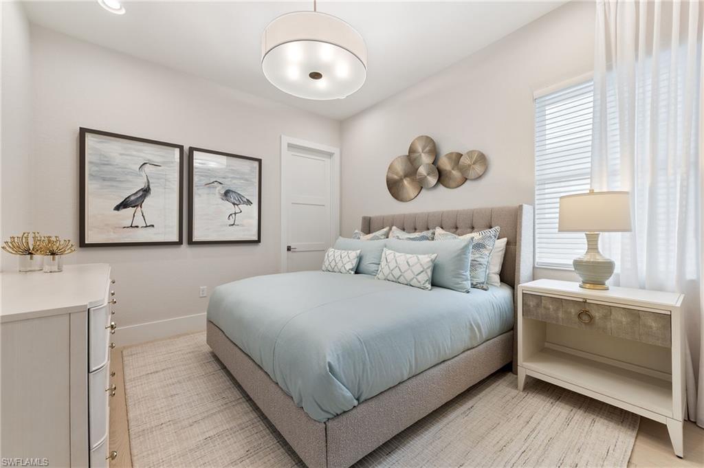 8916 Nevis Way Naples, FL 34112 - Photo 27 of 50 a bedroom with a large bed and a chandelier