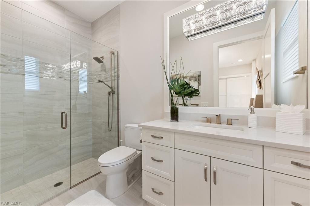 8916 Nevis Way Naples, FL 34112 - Photo 28 of 50 a bathroom with a shower sink vanity mirror and toilet