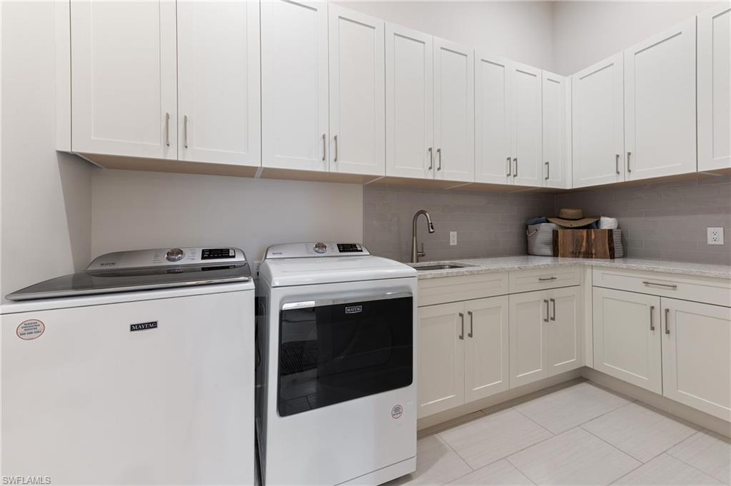 8916 Nevis Way Naples, FL 34112 - Photo 32 of 50 a kitchen with granite countertop white cabinets and white appliances