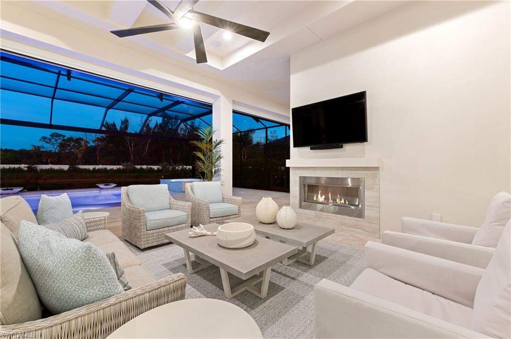 8916 Nevis Way Naples, FL 34112 - Photo 34 of 50 a living room with furniture a fireplace and a flat screen tv