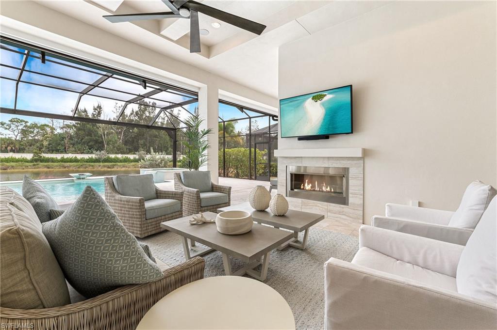 8916 Nevis Way Naples, FL 34112 - Photo 35 of 50 a living room with furniture a flat screen tv and a fireplace