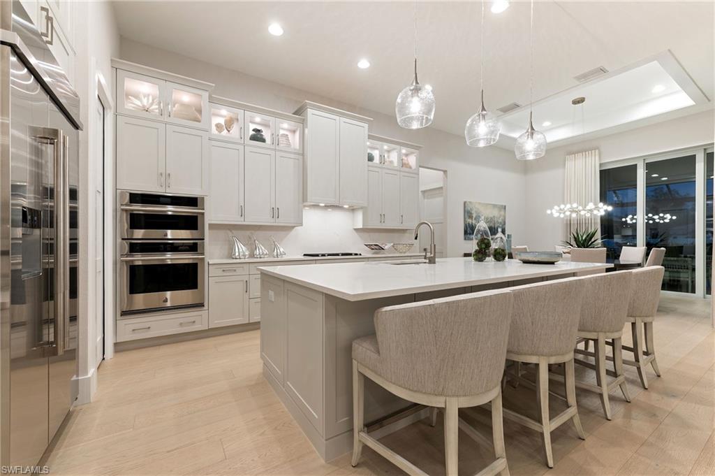 8916 Nevis Way Naples, FL 34112 - Photo 10 of 50 a kitchen with kitchen island granite countertop a sink and stainless steel appliances
