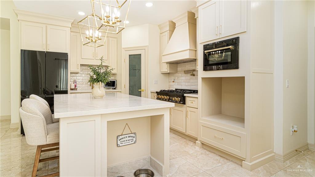 21325 Hibiscus Street Edcouch, TX 78538 - Photo 6 of 17 a kitchen with stainless steel appliances kitchen island granite countertop a refrigerator a stove and white cabinets with wooden floor
