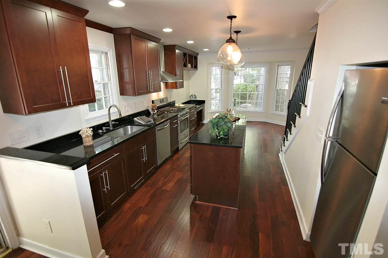 4530 Hamptonshire Drive Raleigh, NC 27613 - Photo 3 of 20 a kitchen with granite countertop a refrigerator a sink a stove a microwave oven a refrigerator white cabinets and wooden floor