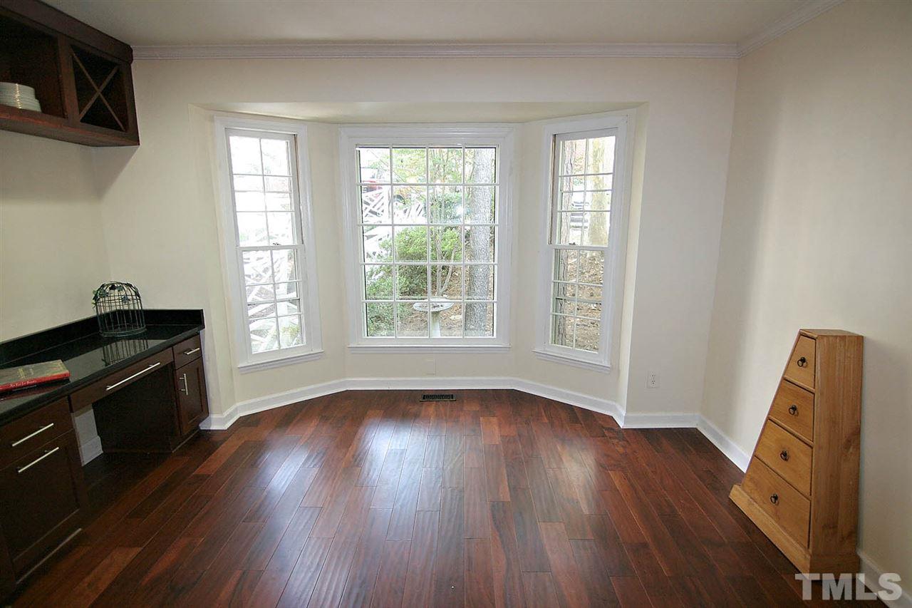 4530 Hamptonshire Drive Raleigh, NC 27613 - Photo 4 of 20 a view of an empty room with wooden floor and a window