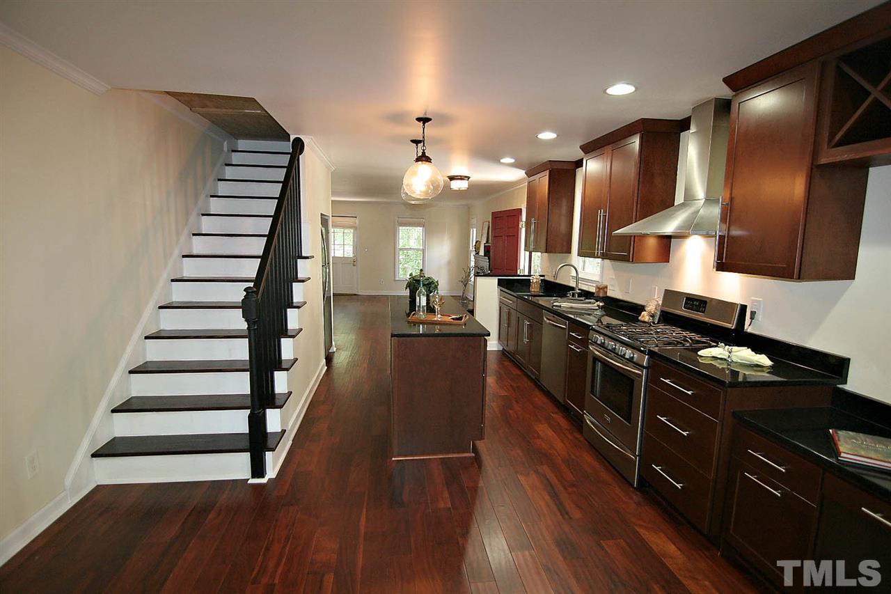 4530 Hamptonshire Drive Raleigh, NC 27613 - Photo 7 of 20 a kitchen with stainless steel appliances kitchen island wooden floors granite top and stove