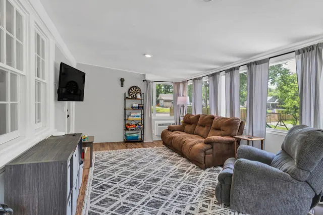 a living room with furniture a flat screen tv and a window