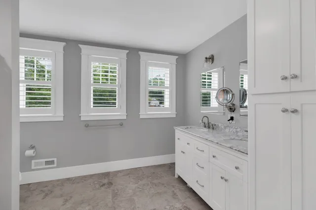 a bathroom with a double vanity sink a mirror and a bathtub