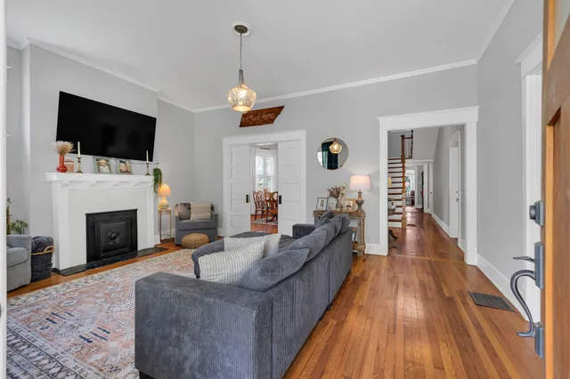 a living room with furniture and a wooden floor