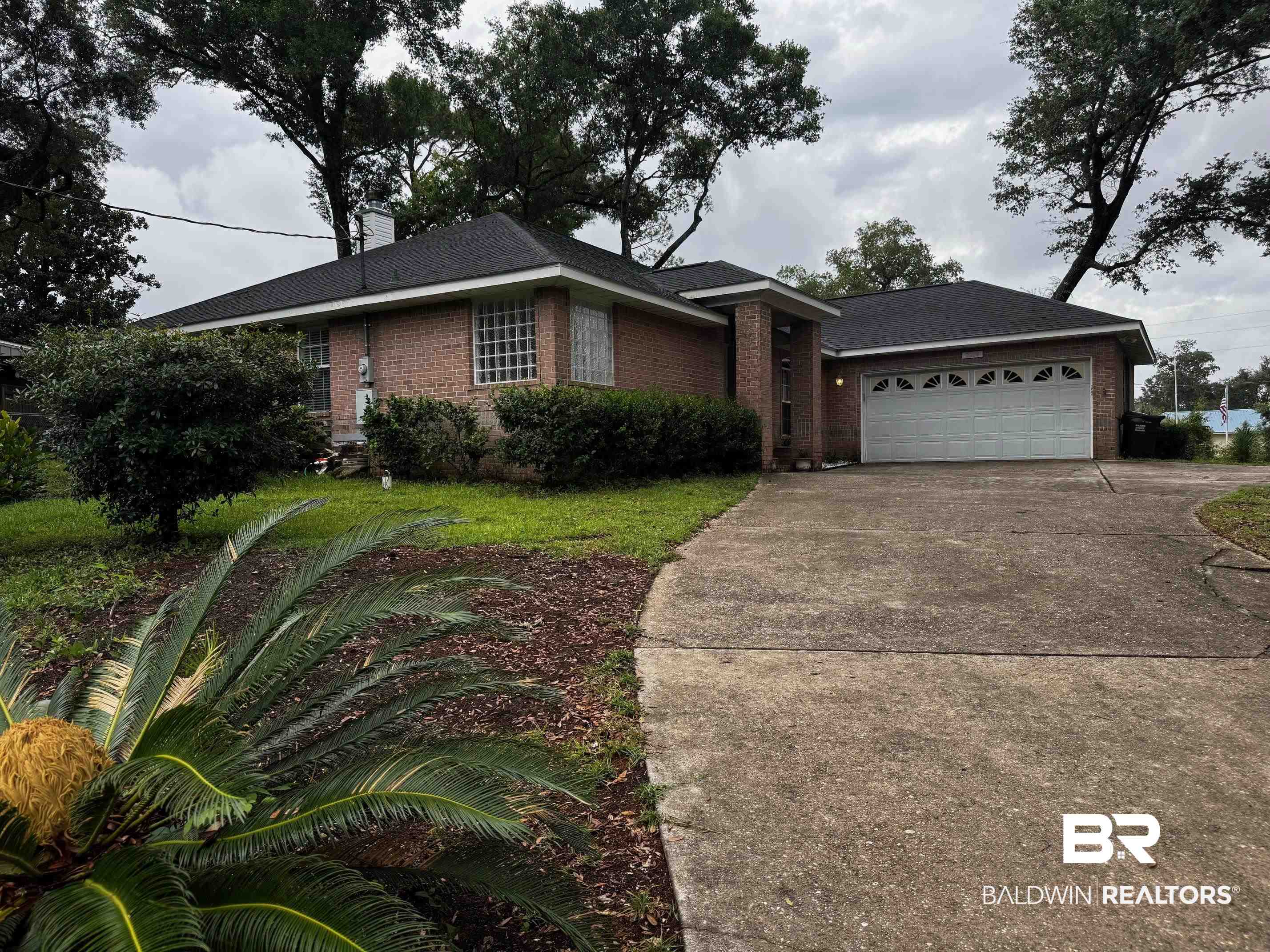 2204 Club House Drive Lillian, AL 36549 - Photo 2 of 38 Ranch-style home with brick siding, concrete driveway, an attached garage, and a chimney