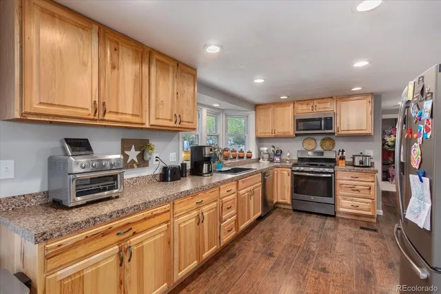 a kitchen with stainless steel appliances granite countertop a refrigerator sink and cabinets