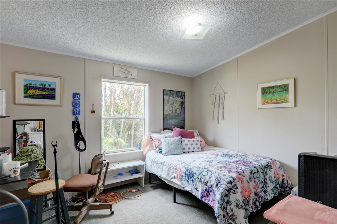 5519 95th Street Sebastian, FL 32958 - Photo 32 of 35 a bedroom with a bed chair and window
