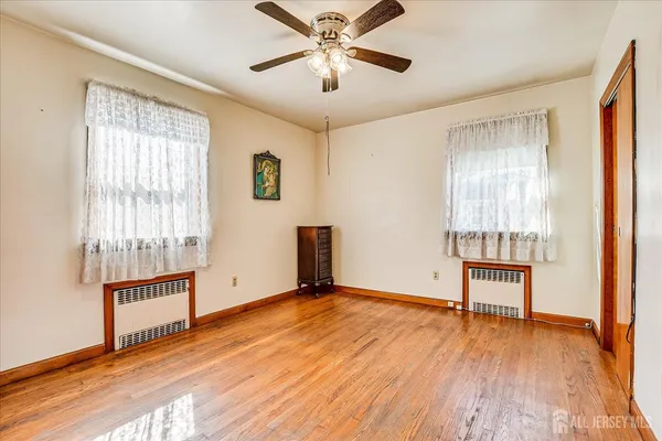 an empty room with windows and ceiling fan