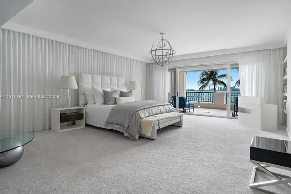 a spacious bedroom with a bed and a chandelier