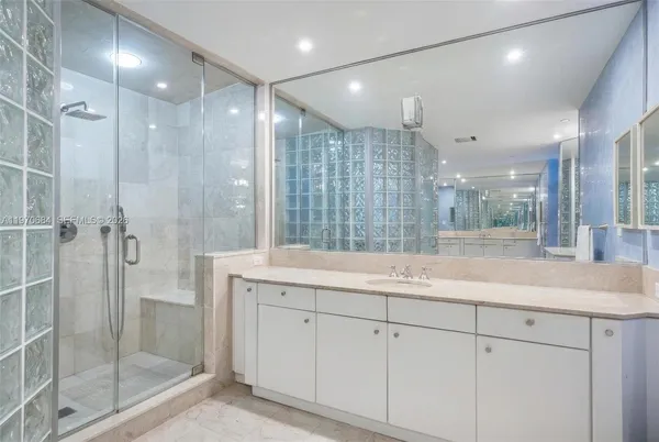 a bathroom with a shower sink and mirror