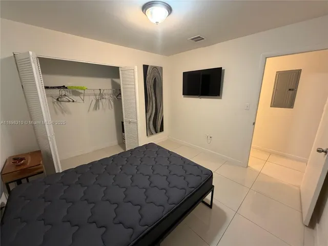 a bedroom with a bed and a flat screen tv