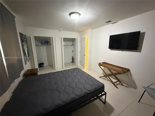 a bedroom with a bed and a chair with the wooden floor