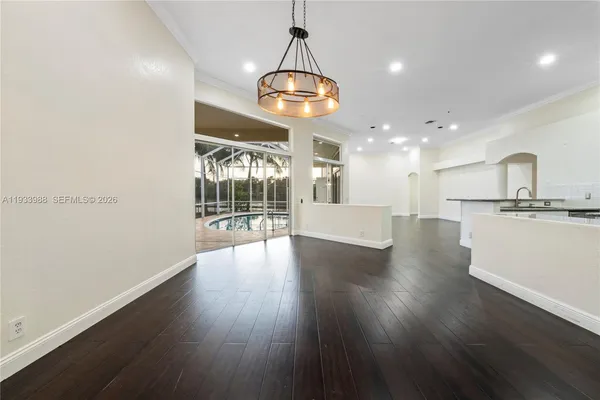 a view of a big room with wooden floor and a chandelier
