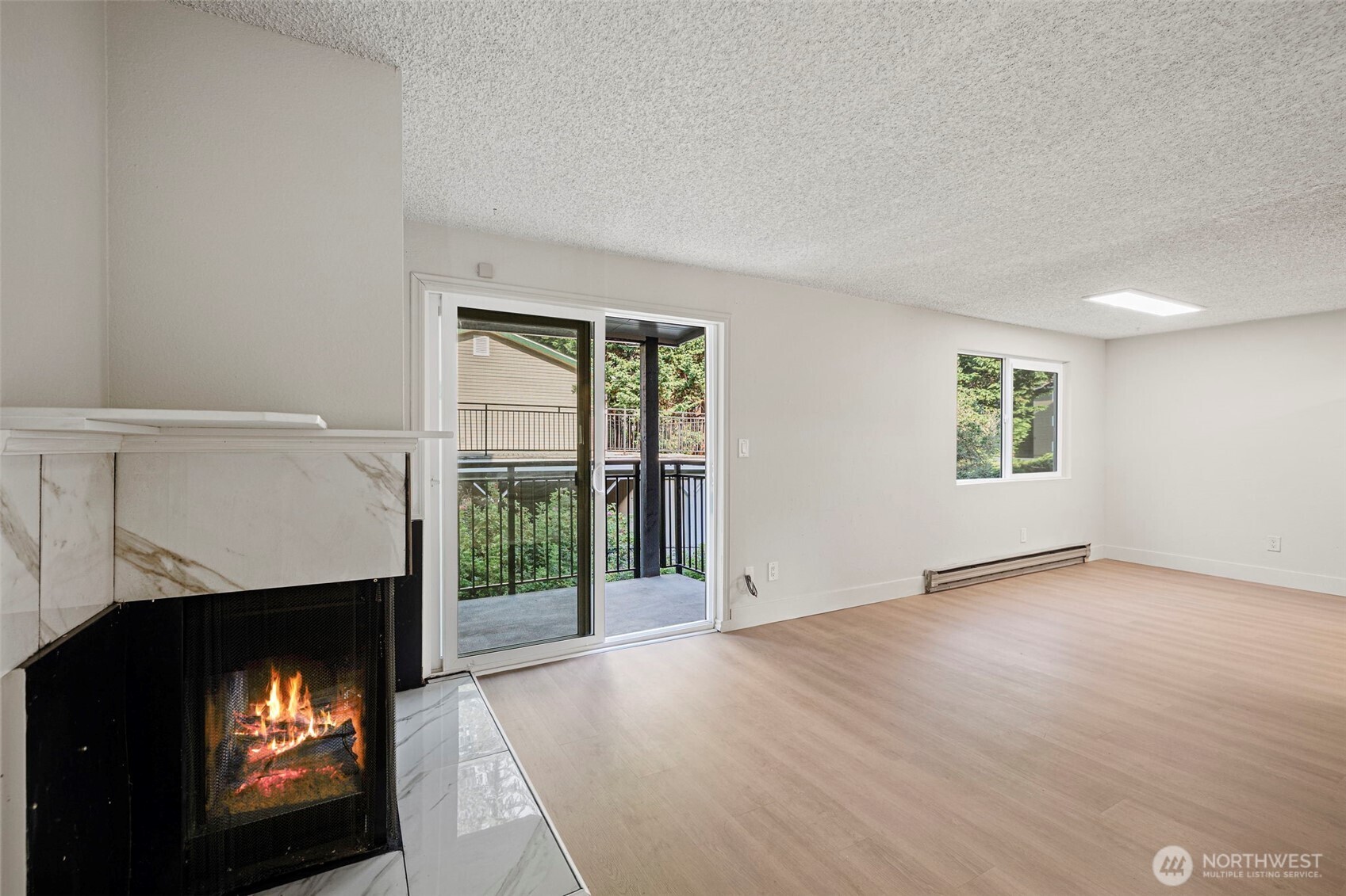 210 Southwest Clark Street, Unit A202 Issaquah, WA 98027 - Photo 7 of 28 an empty room with windows and fireplace