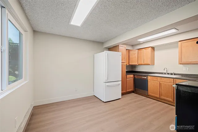 a kitchen with granite countertop a refrigerator and a sink